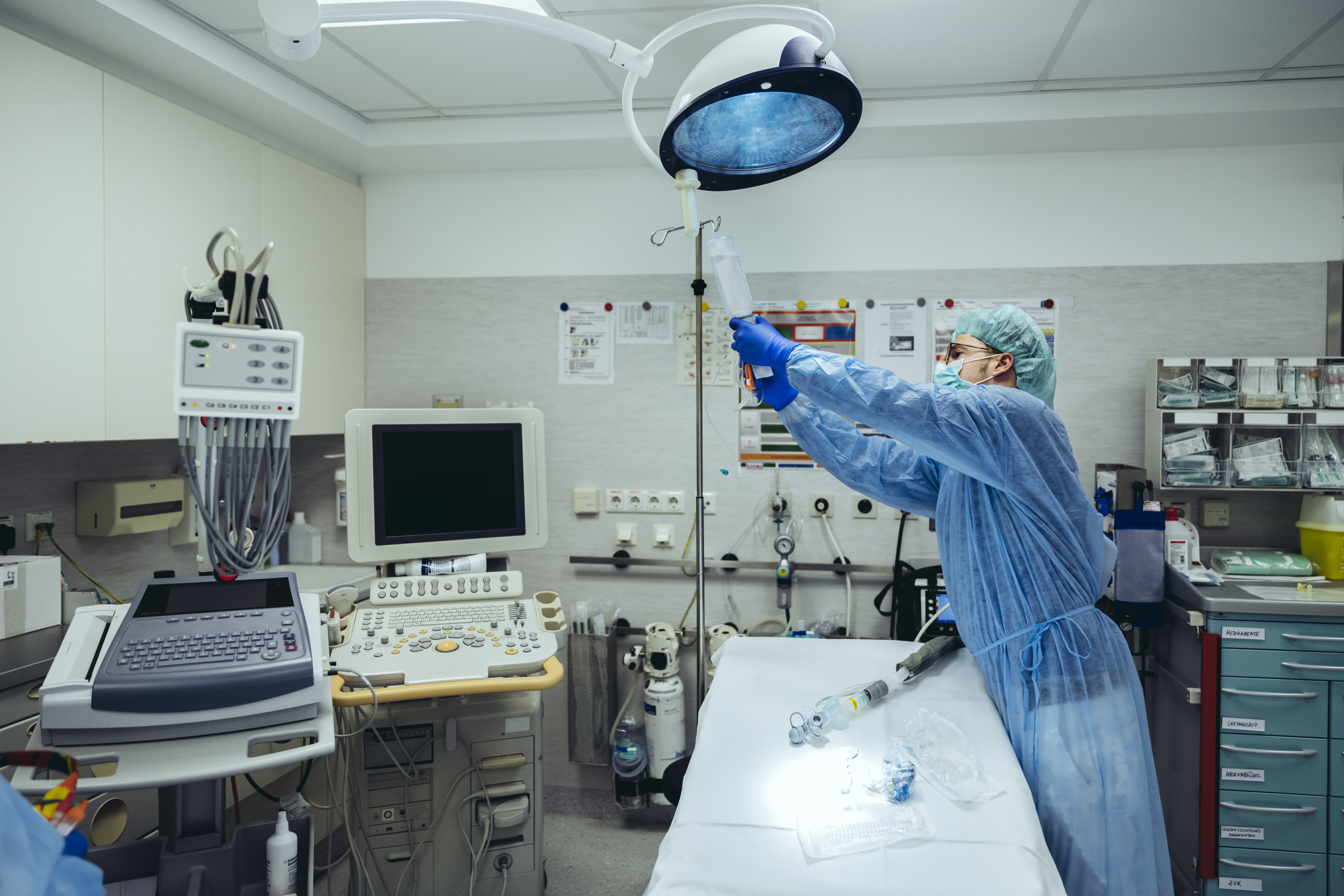 An image of a surgery with a surgical team member preparing the equipment